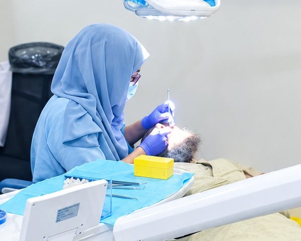 Dentist examining a patient under the treatment light